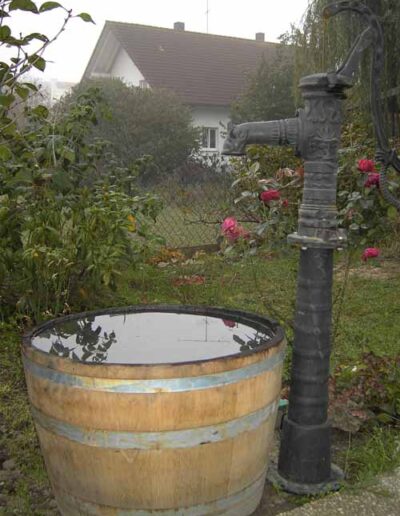 Nostalgische Handpumpe mit halbem Weinfass aus Holz als Brunnentrog von Brunnensysteme Alois Hobmaier